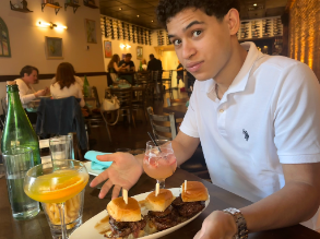 Jared at a restaurant table with sliders and a drink